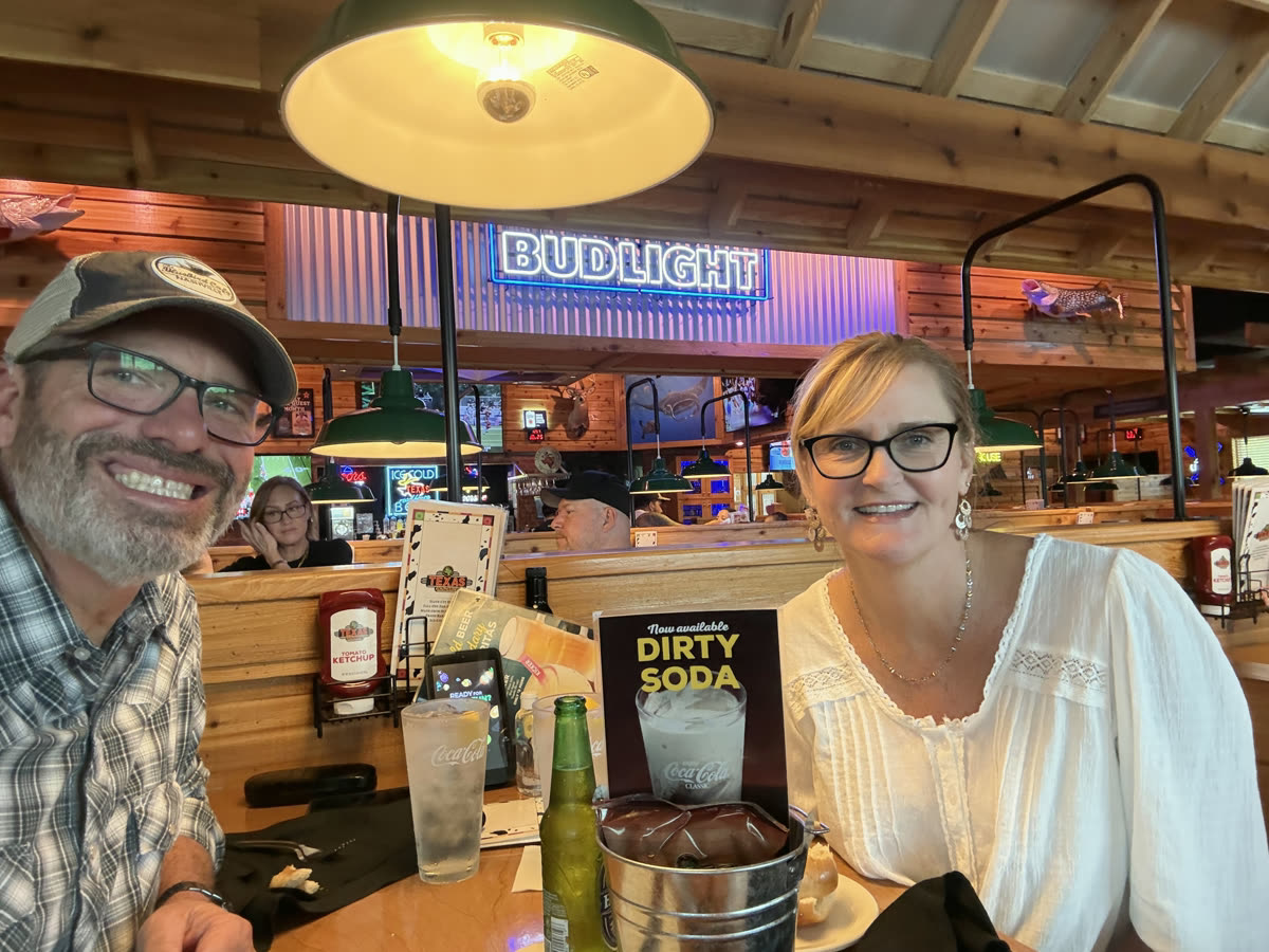 Brett and Shay smiling across a restaurant booth