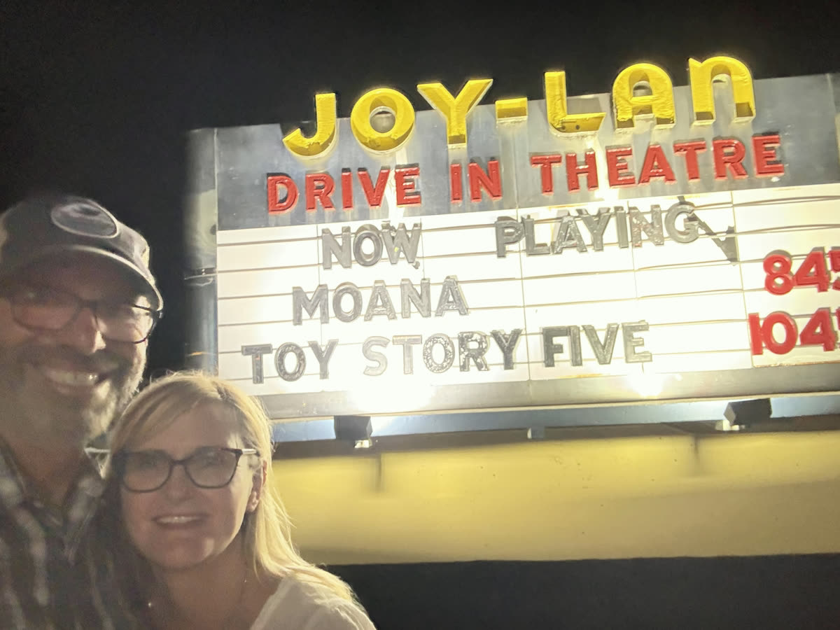 Shay and Brett under the lit Joy-Lan Drive In Theatre marquee at night